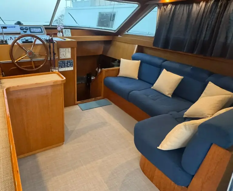 Bamby's saloon with blue sofas, pale cushions and wooden wheel