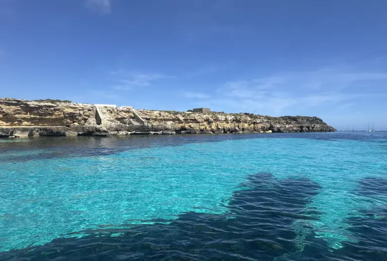 Turquoise water below Favignana's tuff coast