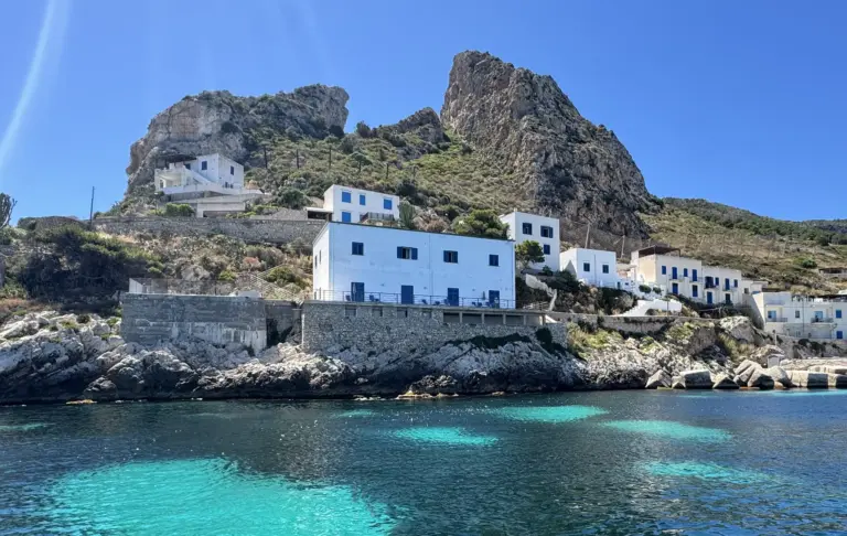 Levanzo's white village below the Pizzo, clear water