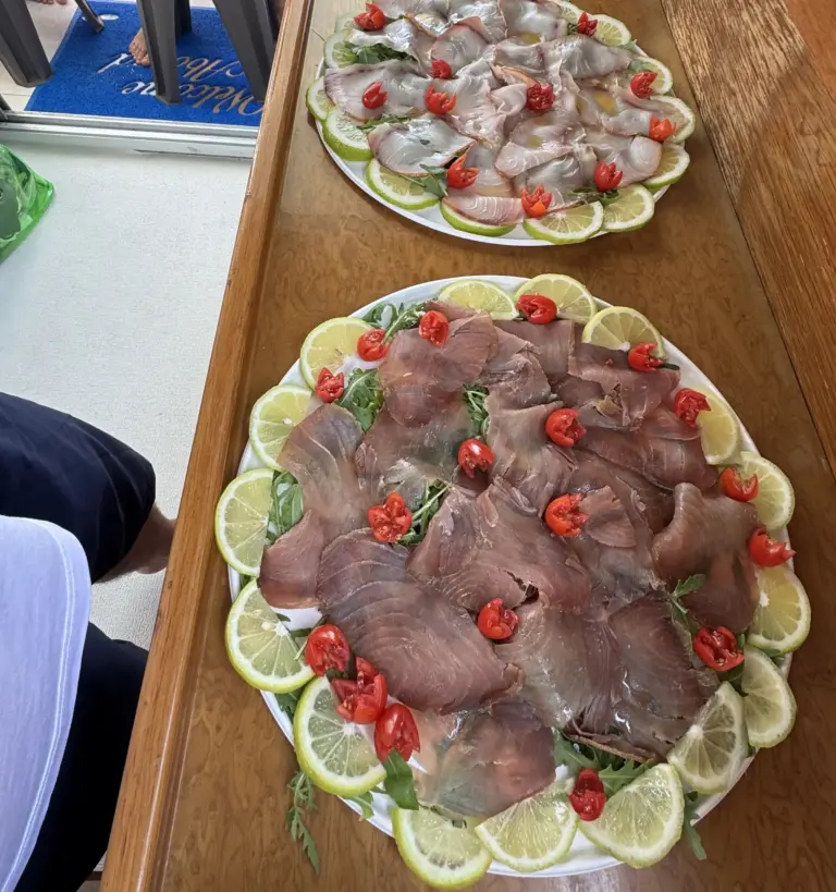 Fish carpaccio with lemon and cherry tomatoes, on request on the boats